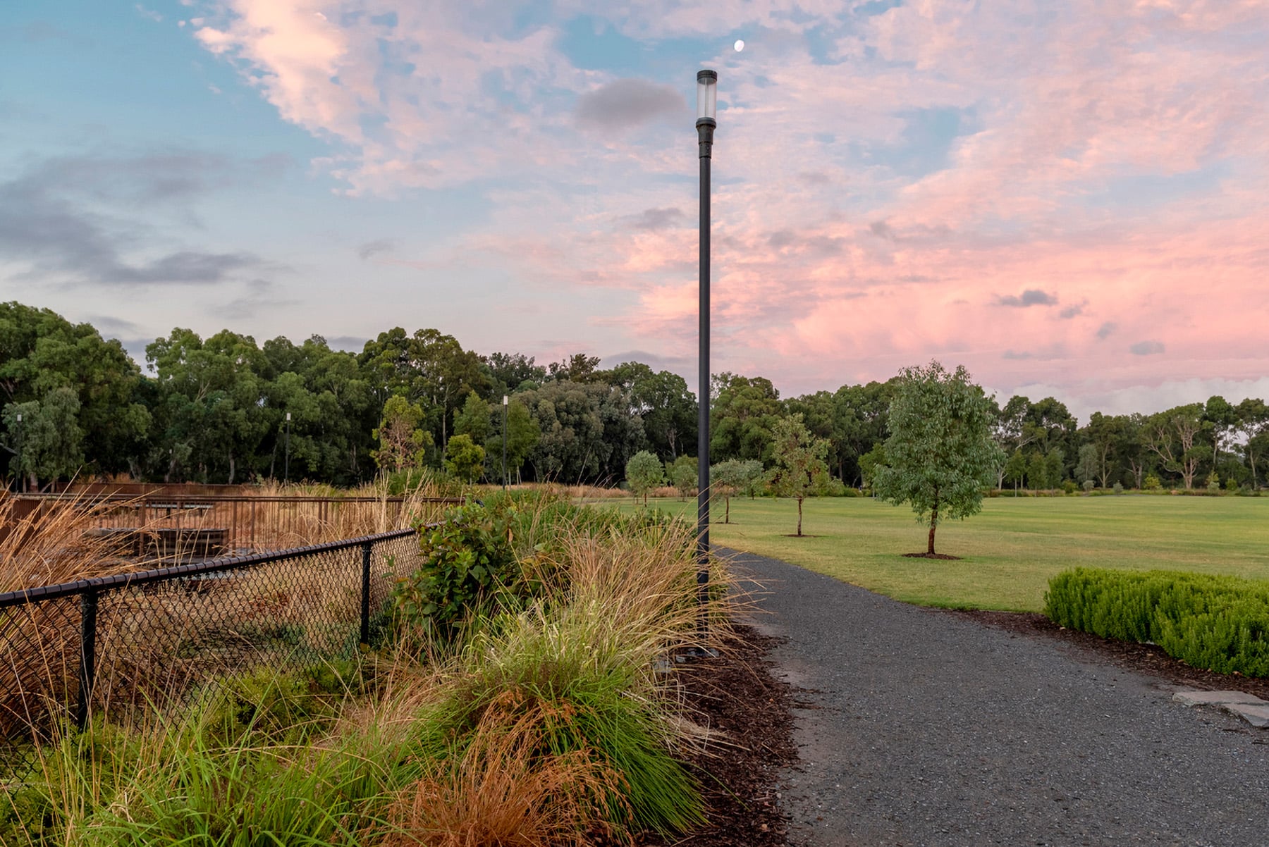 ZFT400 pole-mounted luminaire illuminating a footpath surrounded by greenery in a park setting.