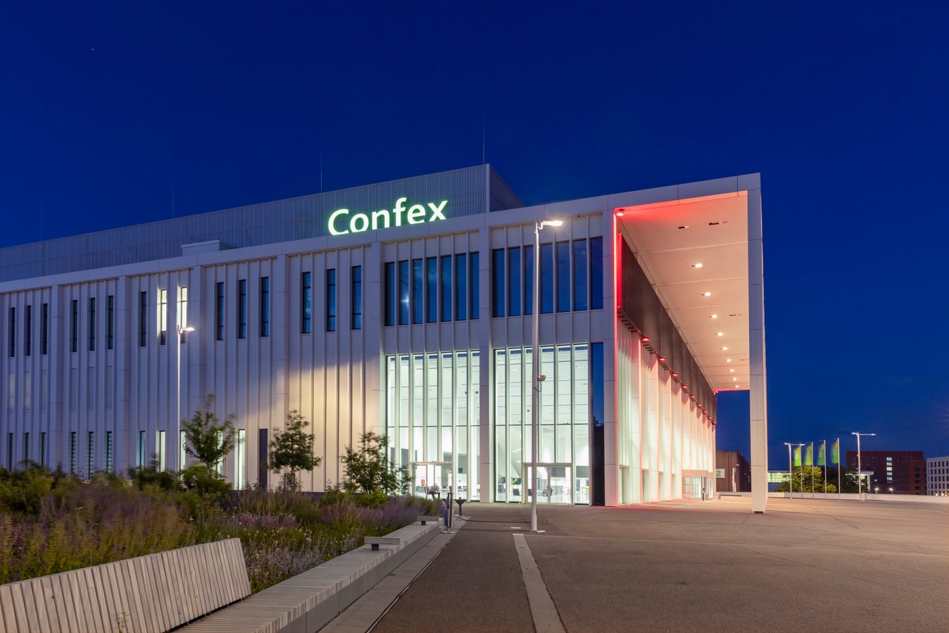 A modern building with an illuminated façade and a large entrance area at night.